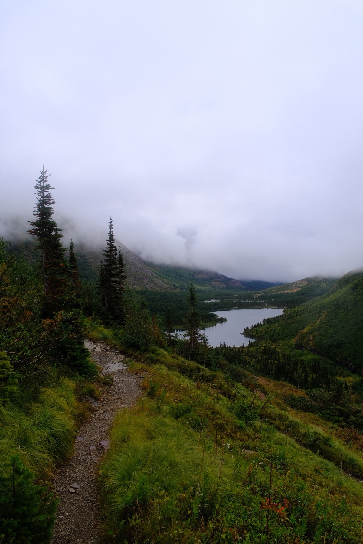 A waterfall below cloud-covered cliffs