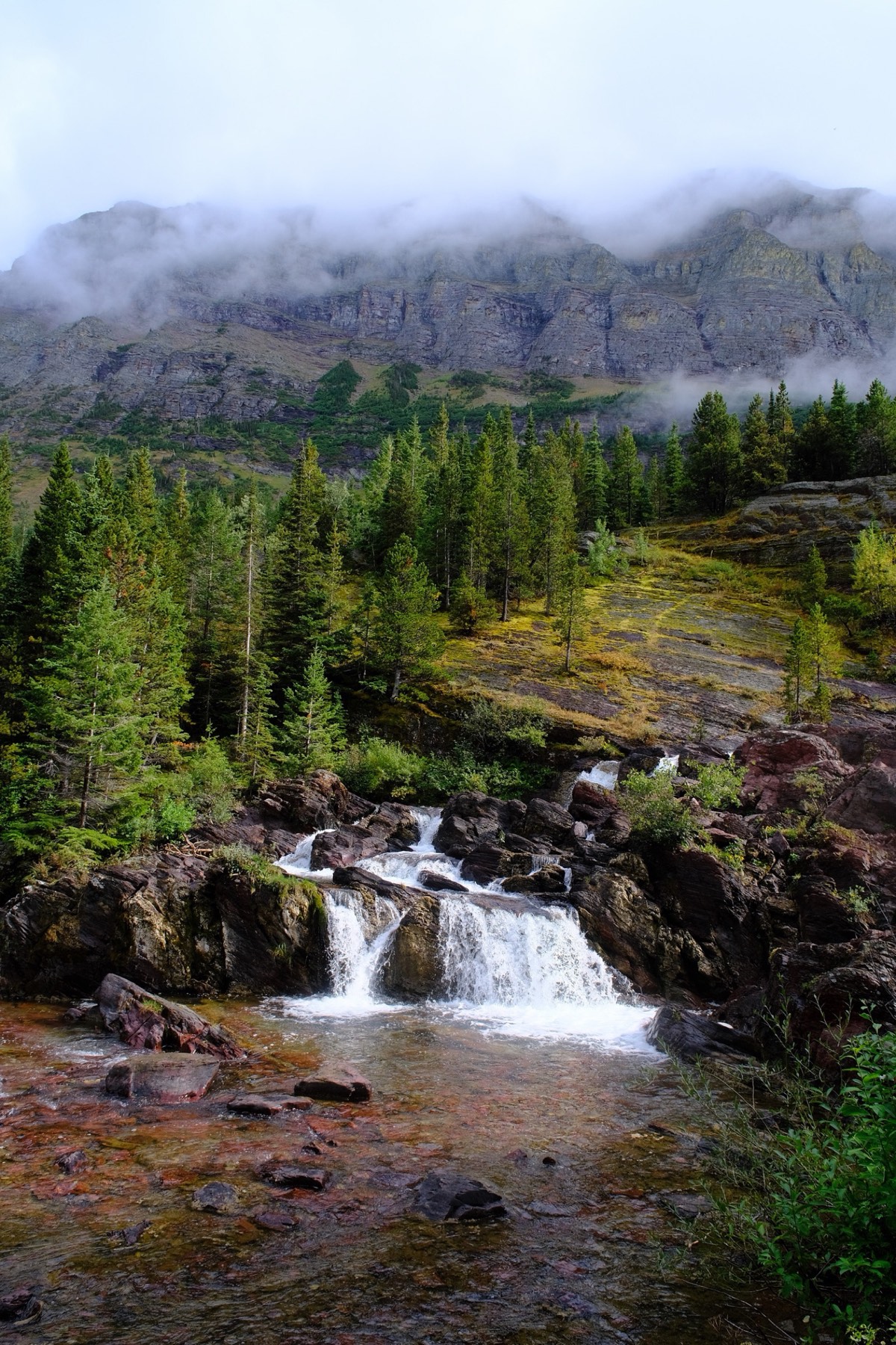 A lake below the trail, half swallowed by cloud